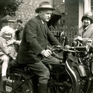 Man on veteran motorcycle with young girl