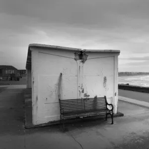 Man and woman walk along the sea front in high winds, Troon