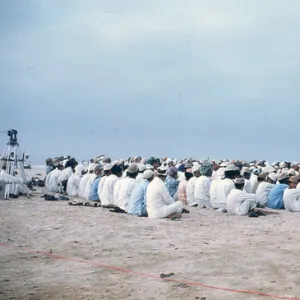 Men and young boys sitting on the beach in Oman