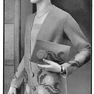 Model wearing an embroidered jacket and carrying a matching embroidered pochette, made of perforated wool net fabric. Date: 1920s Model wearing an embroidered jacket and carrying a matching embroidered pochette, made of perforated wool net fabric. Date: 1920s