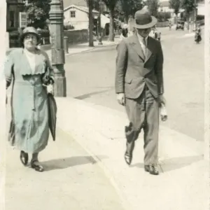 Mother and adult son stroll along a Worthing pavement Mother and adult son stroll along a Worthing pavement
