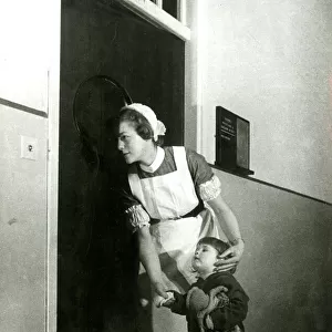 Nurse holding childs hand, looking in on an operation