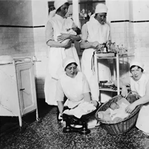 Nurses weighing babies