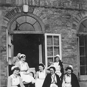 Six nurses and woman on steps