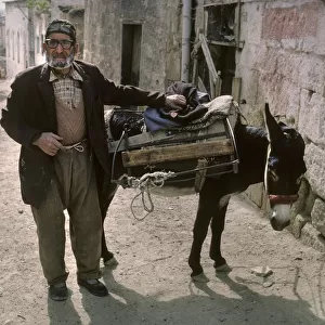 An old man with a donkey in a back street of Avanos