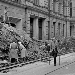 People in a bomb damaged street during WW2