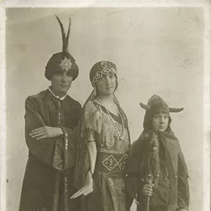 Three people in fancy dress; two adults in exotic Arabian Nights style outfits