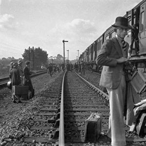 People on a railway track alongside a train