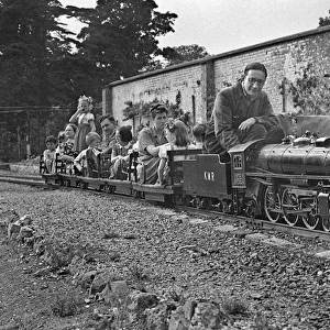 People riding on a miniature steam train