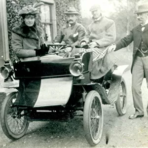 Four people with a veteran antique car