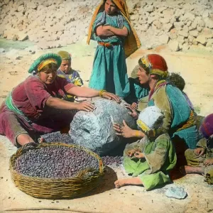 Persian women using a large grindstone, Iran