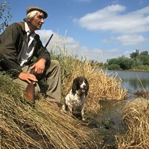 Poacher with gun and dog, Cambridgeshire fens