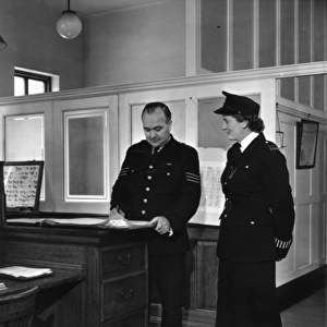 Two police officers working in a station, London