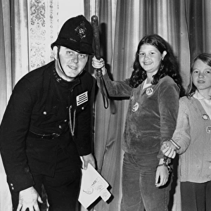 Policeman in 1920s uniform, with two girls