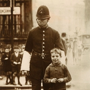 Policeman helping a young boy cross the road