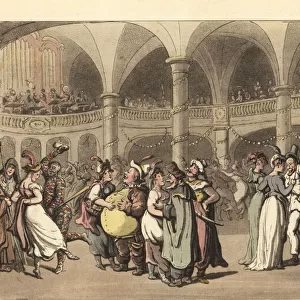 Revellers in costume at a masked ball in a large theater