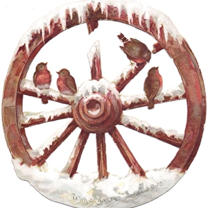 Robins perched on a wheel on a cutout Christmas card