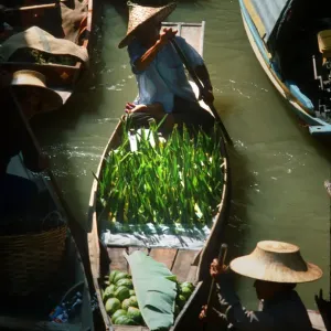 Seller paddles his boat into Damnoen Saduak floating market Seller paddles his boat into Damnoen Saduak floating market