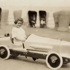 Small girl in a pedal car