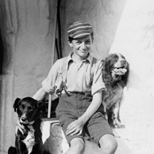 A smiling schoolboy and his two dogs