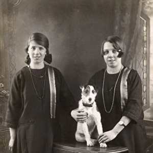 Studio portrait, two girls with terrier