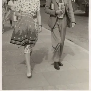 Stylish couple on holiday in Paignton walk along seafront