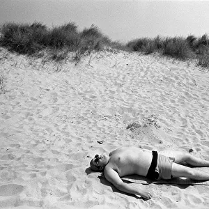 Sunbathing man on beach Newport, near Great Yarmouth
