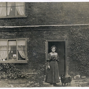 Woman and dog outside a farnhouse