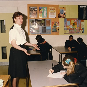 Woman police officer talking in a school classroom