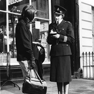 Woman police officer and woman with handbag, London