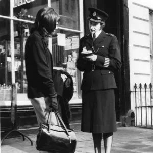 Woman police officer and woman with handbag, London