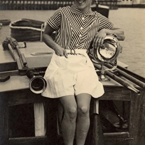 Woman poses on boat, 1930s