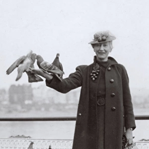 Woman at seaside with pigeons