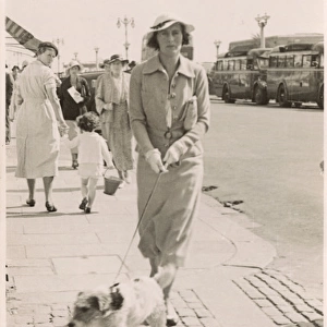 Woman with terrier on a lead at the seaside