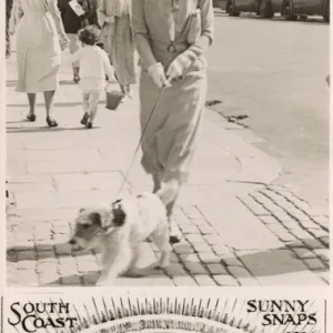 Woman with terrier on a lead at the seaside