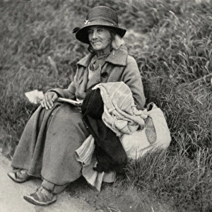 Woman tramp sitting at side of road