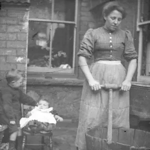 Woman using a dolly tub in a back yard, South Wales