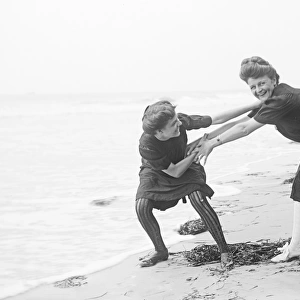 Two women in period bathing costumes on the beach in America