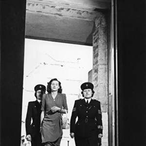 Two women police officers escorting woman, London