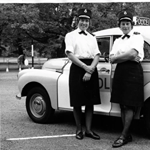 Two women police officers standing by a car, London