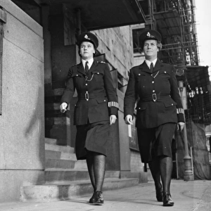 Two women police officers walking along London street