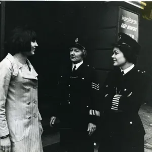 Two women police officers with woman on London street