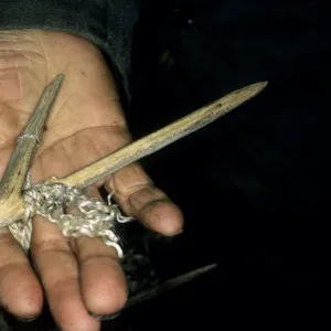 Wooden fishing hook on palm of a Siberian shaman /