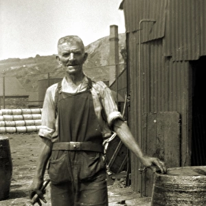 Workman in overalls with barrel