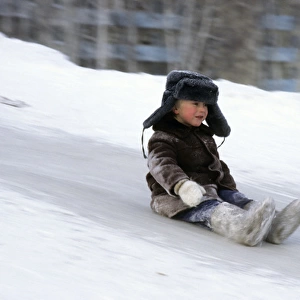 Young boy does downhill-ice-sliding just on his