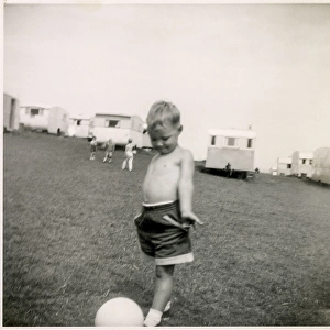 Young boy plays with a football at a holiday camp