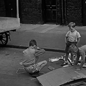 Three young boys playing in street, London