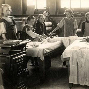 Young girls ironing in laundry room, Surrey