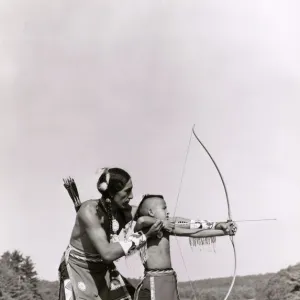 Young Native American Indian boy learning to shoot his bow