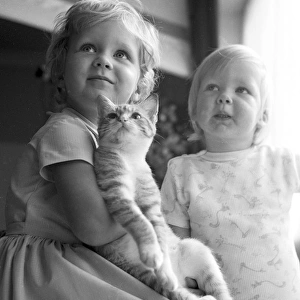 Two young sisters and their pet cat